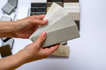 Mock up from natural stones, top view, closeup. Female hands advertises repair materials. Floor...