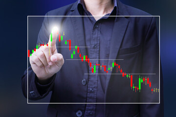Business man person point finger at graph float at screen in concept of finance stock trade and growth of wealth with blur background