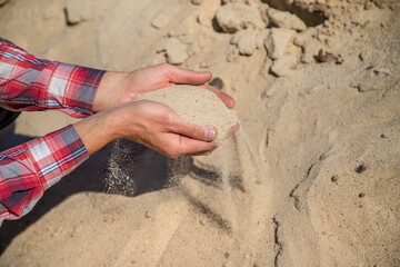 Sand quarry in the hands of a man. Selective focus.