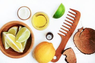 Healthy hair care beauty treatment ingredients, top view white table wooden natural haircomb, lemon citrus slices, fresh lime scent essential oil herbal extract in bowl - obrazy, fototapety, plakaty