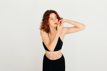 Naklejka premium Thoughtful cute redhead woman holding hands near her face, looking ti the side, standing over white background