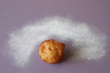 Fried donut with a nimbus from sugar powder.