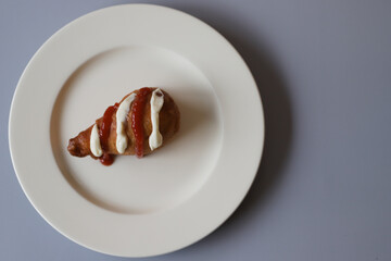 Fried donut in the form of chicken leg with mayonnaise and ketchup.