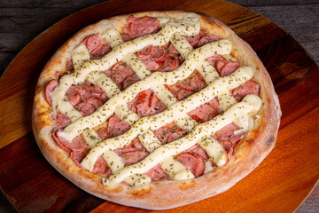 pepperoni pizza with and catupiry cheese on wooden background, in Brazil it is called pizza de...