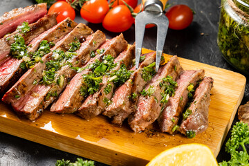 Juicy pieces of steak, medium rare on a wooden board.