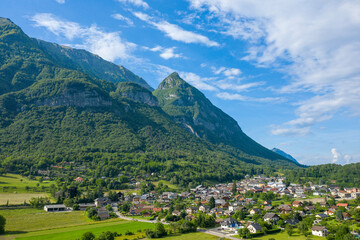 Fototapeta na wymiar The town of Gresy sur Isere under its mountain in Europe, France, Isere, the Alps, in summer on a sunny day.