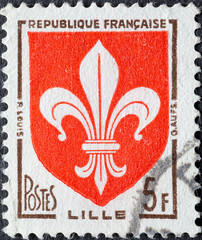 France - circa 1958: A post stamp from France showing the historic coat of arms of Lille in white...