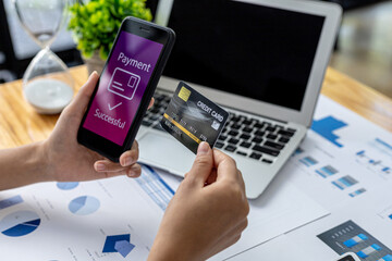 Person holding a smartphone at the screen of an online payment website, using a smartphone to pay for goods via credit card online. Concept of using smartphones to pay for products via credit card.