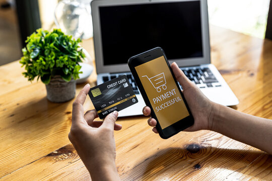 Person holding a smartphone at the screen of an online payment website, using a smartphone to pay for goods via credit card online. Concept of using smartphones to pay for products via credit card.