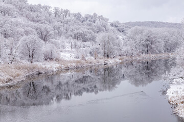 River landscape and trees covered with fresh snow during winter Christmas.