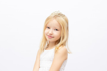 Funny little princess girl in silver crown and white dress over white background