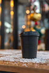Takeaway disposable cup for hot drink on wooden table. Street walk cafe. Coffee, tea or mulled wine to go. Empty space for text, mockup.