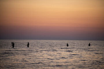 Pescatori al mare al tramonto.
