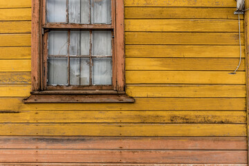Obraz na płótnie Canvas Aged rustic wooden background texture in yellow with older window. copy space