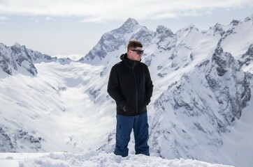 Fototapeta na wymiar Portrait of a man on top of a snowy mountain