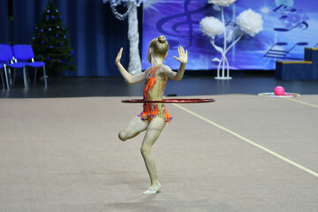 The girl performs a mandatory program in rhythmic gymnastics 