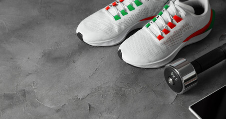 Concept of sports shoes for training, dumbbells, smartphone on a gray background - Powered by Adobe