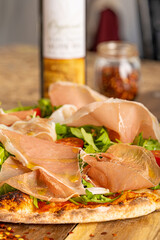 Prosciutto Arugula and Tomato Pizza Drizzled with Extra Virgin Olive Oil