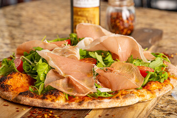 Prosciutto Arugula and Tomato Pizza Drizzled with Extra Virgin Olive Oil