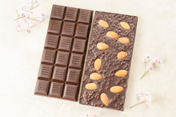 assortment chocolate bars with almonds, handmade sweets. Composition of bars milk and dark almond chocolate on black background, top view. Pastry craft on the table
