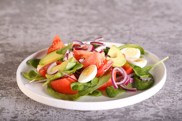 fresh salad with avocado red onion tomatoes and spinach