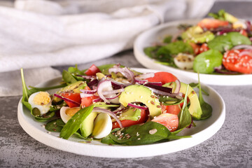 fresh salad with avocado red onion tomatoes and spinach