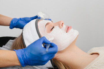 Consultation in cosmetology clinic. Female professional beauty doctor talking with pretty young female.