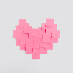 Creative layout pink coral heart shape made with stickers paper sheets or note papers on white background. Minimal love concept of valentines day. Flat lay.