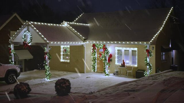 A nighttime snowy winter establishing shot of a typical Pennsylvania home's Christmas lights turning on. Pittsburgh suburbs.  	