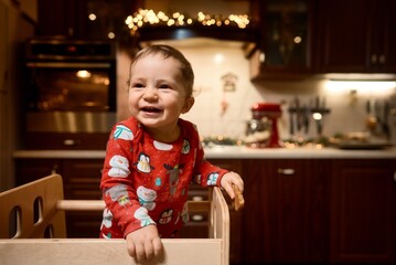 baby boy in pajamas in Christmas kitchen. High quality photo