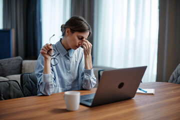 Frustrated young woman overworked by computer take off glasses suffer of sore eye, vision problem,...