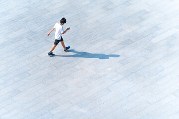 Top view of student with fashion cloth and sport wear walking at pedestrian walkway outdoor for traveling or exercise for healthy. boy preparing to school at landscape public street in city.