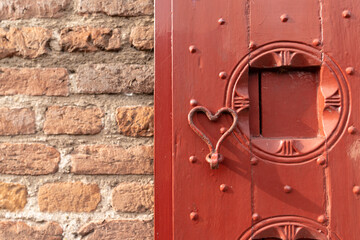 Windowpane with shutter in red and ironware whaped like a heart