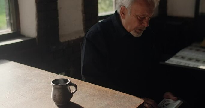 Sad old gray haired man looks to the portrait of lost close friend, sorrow and depression and mental breakdown , 4k 60p Prores