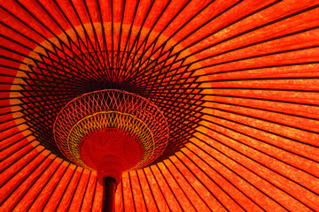Close up photo of a bright red traditional Japanese garden sunshade umbrella