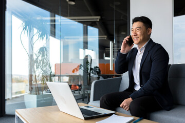 Asian businessman smiling and rejoicing happy talking on the phone, freelancer man in modern office...