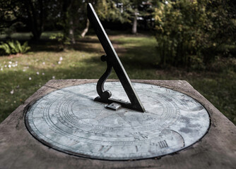 old sundial in muted colour to convey age and showing the development of technology from an ancient...
