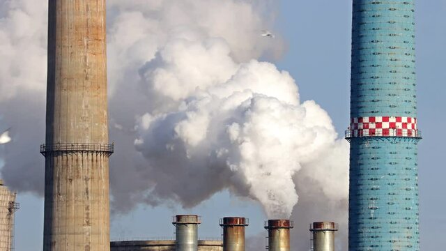 Zoom at a thermal power station in Bucharest, Romania. The factory chimney is polluting the atmosphere.