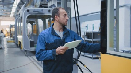 Railway engineer young caucasian technologist learning building plan browsing tablet constructing new modern city trams. Factory. Professional.