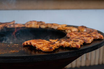Barbecue, outdoor cooking, gastronomy, cookery, street food concept. Process of cooking fresh juicy meat steaks on brazier at summer local food market - close up view