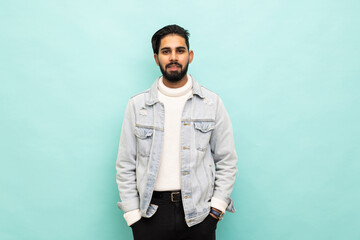 Smiling indian man standing in front of turquoise wall