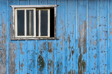 Obraz na płótnie Canvas Aged rustic wooden background texture in blue with older window.