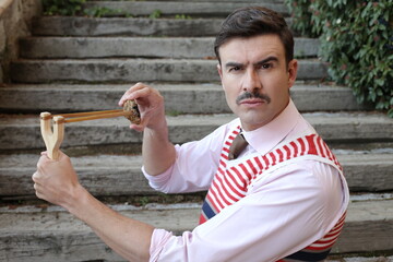Elegant man with a mustache holding vintage slingshot - obrazy, fototapety, plakaty
