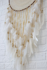 White dreamcatcher hanging on white wall