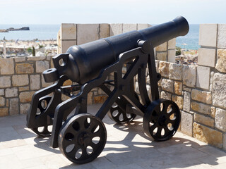antique cannon aimed at the sea on the fortress wall
