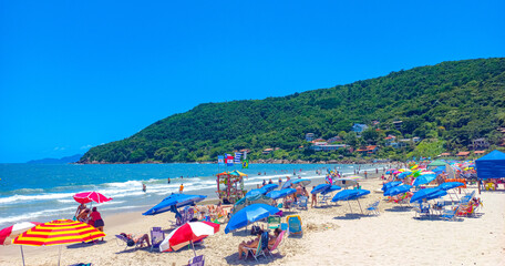 Fototapeta na wymiar people on the beach and umbrellas and sun and crowded beach at Lagoinha do Norte beach in Florianópolis, Santa Catarina, Brazil, floranopolis
