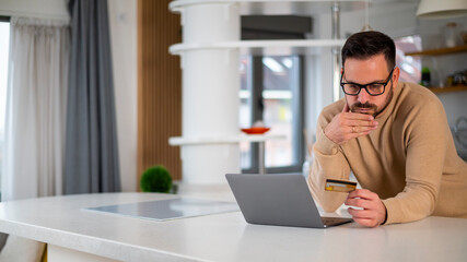 Stressed young man holding a credit card. Problems with online payment, financial difficulties,...