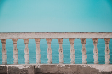Closeup of a concrete balustrade on a blue sky with clouds 