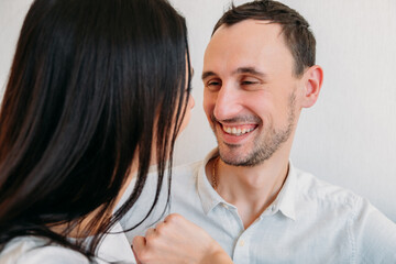 Happy face of young man close-up who is smiling while looking at girl. Positive communication of young people at home. Love and relationships