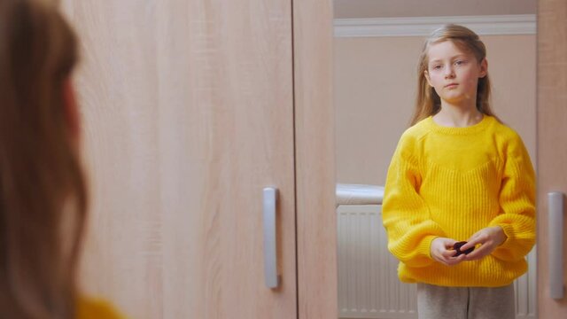 Girl tying hair in front of the mirror